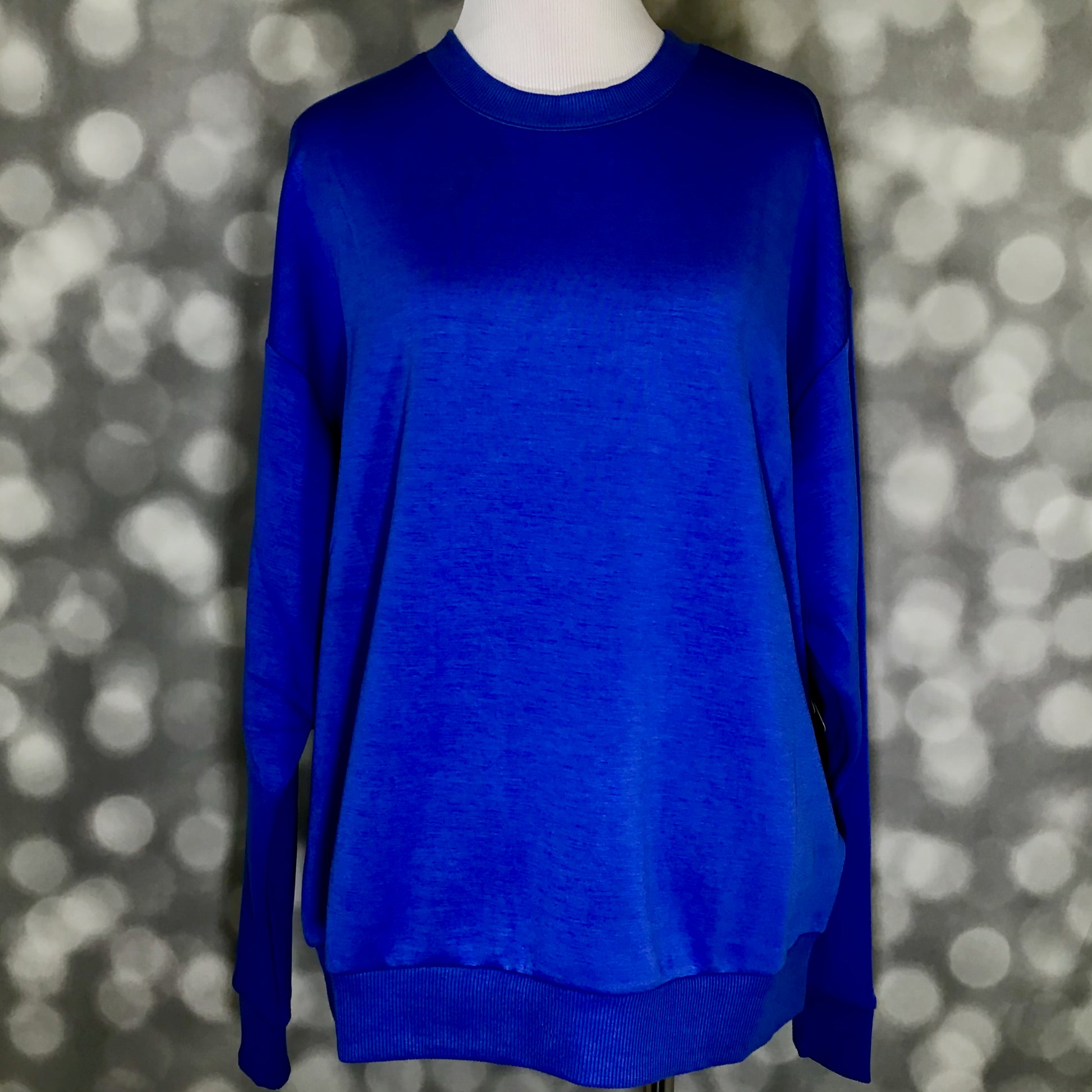 Rise Reset Crewneck Pullover in solid royal cobalt blue with an oversized relaxed fit and ribbed hem on a mannequin against a blurred background