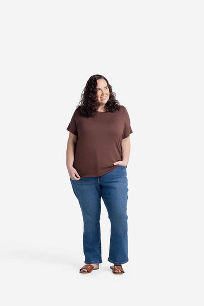 Woman wearing LuLaRoe Essential Tee in Solid Cocoa Truffle featuring a rich medium brown color, classic crew neckline, short sleeves, and a semi-relaxed fit in soft luxe modal fabric on a white background