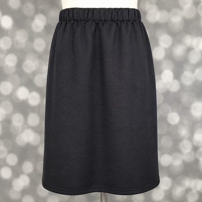 LuLaRoe Samantha Skirt in Solid Deep Charcoal, a women's pull-on midi skirt featuring a non-roll elastic waistband and soft Modal Scuba fabric. Deep charcoal gray skirt with a flattering silhouette, ideal for workwear, casual outfits, travel, and year-round styling on a mannequin against a blurred background. 