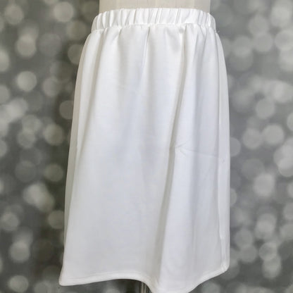 LuLaRoe Samantha Skirt in Solid White, a women's pull-on midi skirt featuring a non-roll elastic waistband and soft Modal Scuba fabric. Classic white skirt with a flattering silhouette, ideal for casual wear, vacation outfits, workwear, and year-round styling on a mannequin against a blurred gray background